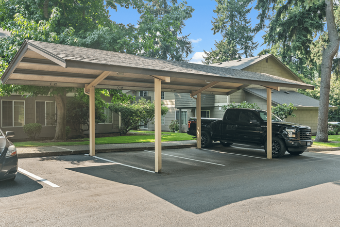 Charming covered parking area amidst lush greenery, providing convenient and secure vehicle space for residents.