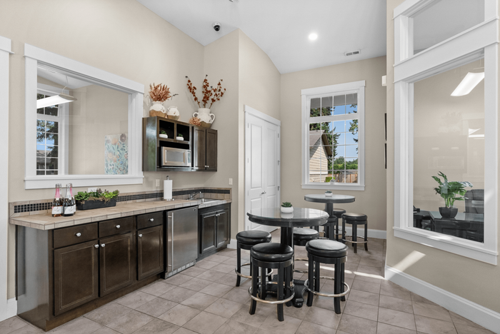 Inviting kitchen with elegant cabinetry, stainless steel appliances, and charming breakfast nook featuring natural light through large windows.