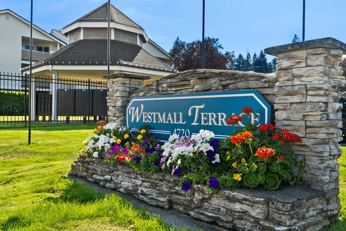 Charming entrance sign of Westmall Terrace adorned with vibrant flowers, highlighting welcoming community ambiance.