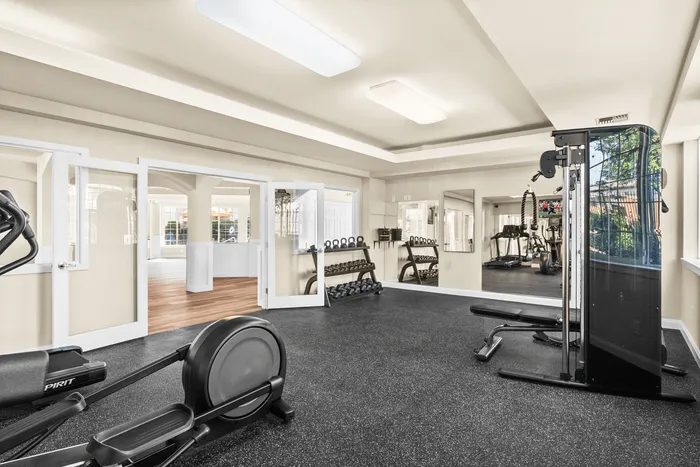 Bright and modern fitness center equipped with state-of-the-art exercise machines, free weights, and spacious workout areas.