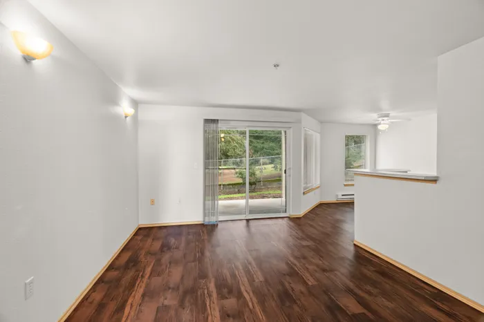 Inviting living space featuring elegant hardwood floors, bright natural light, and access to a charming outdoor view.