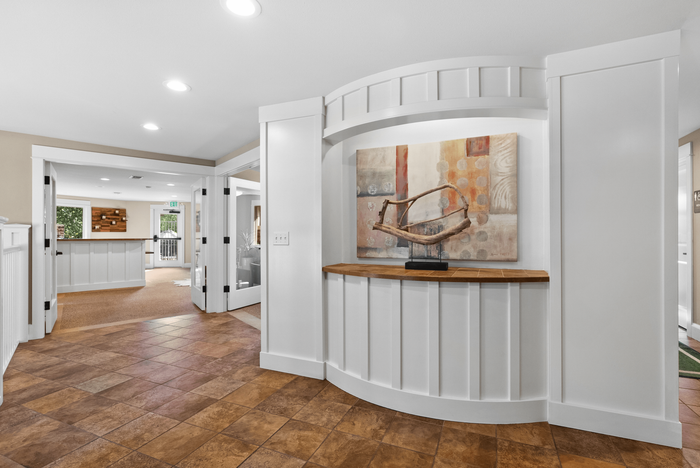 Elegant entrance hall with warm lighting, modern decor, and artful wall design creating a welcoming atmosphere.