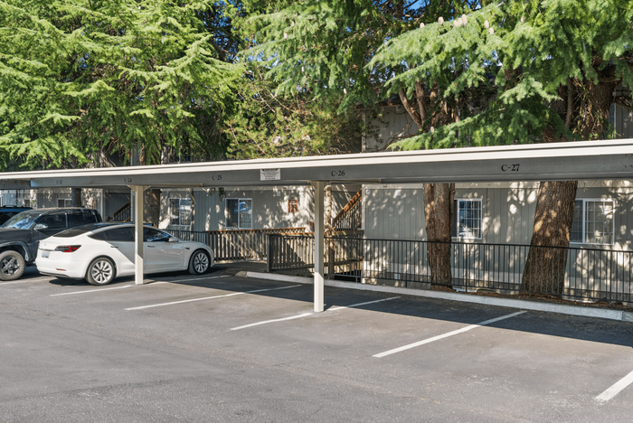 Convenient covered parking with lush greenery, offering ample shade and a welcoming atmosphere for residents.