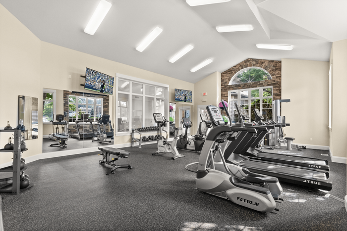 Bright, modern fitness center featuring state-of-the-art exercise equipment, large windows, and sleek design.
