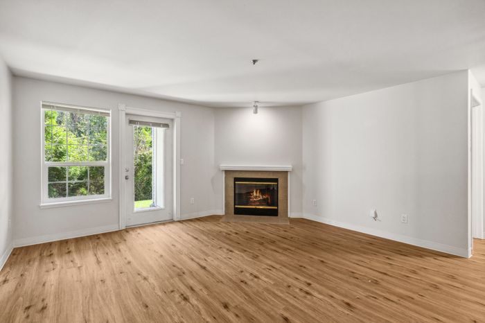 Inviting living room with natural light, elegant flooring, and a cozy fireplace, creating a warm atmosphere.
