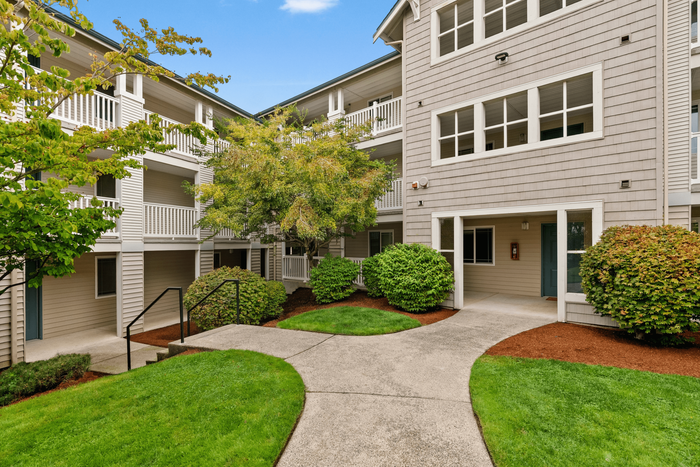 Inviting apartment complex courtyard featuring lush greenery, charming pathways, and classic architectural design.