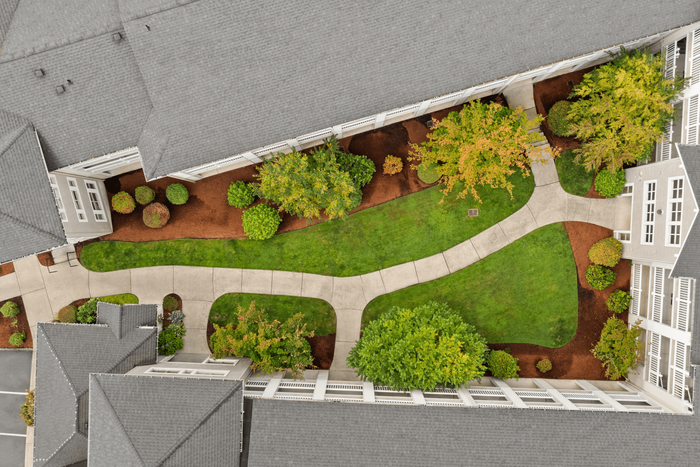 Stunning aerial view of a modern apartment complex showcasing well-manicured gardens and inviting pathways.