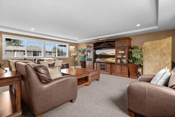 Luxurious living room with elegant leather sofas, large windows, and a sophisticated entertainment center.