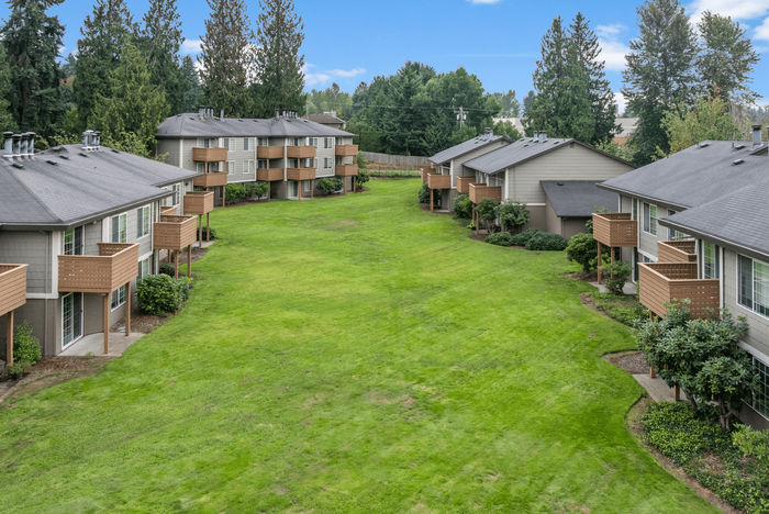 Charming apartment complex surrounded by lush greenery, featuring spacious balconies and serene outdoor spaces.