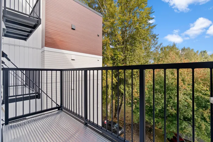 Charming balcony view with lush greenery and modern architecture, perfect for relaxation.