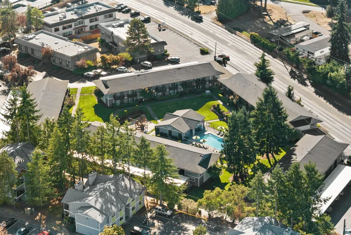 Charming apartment complex with lush greenery and an inviting pool area, offering a serene living environment and modern amenities.