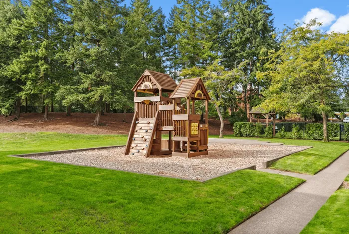 Inviting outdoor playground nestled in lush greenery, offering a delightful wooden play structure for children.