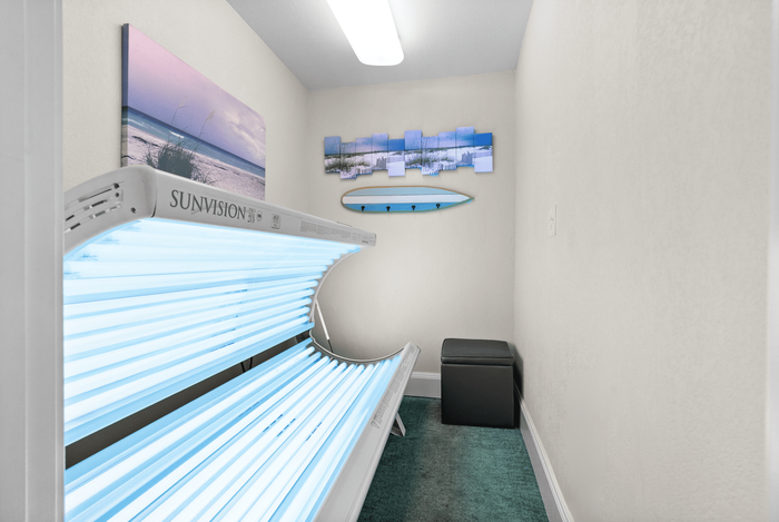 Modern apartment feature with stylish sunbed room, serene beach artwork, and surfboard decor for a relaxing vibe.