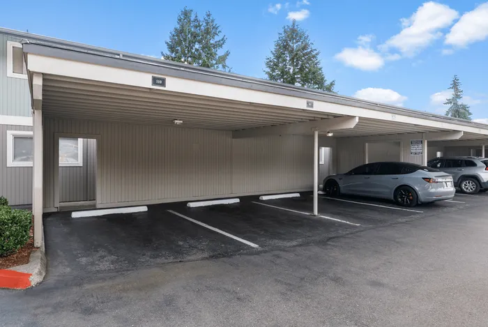 Covered parking area with modern cars, showcasing spacious and convenient parking facilities.