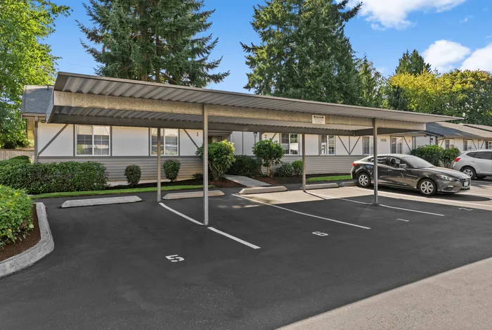 Inviting apartment complex with covered parking and lush green landscaping, offering convenience and style.