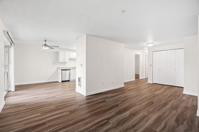 Bright and spacious open-concept living area with elegant wooden flooring, modern kitchen, and ample natural light.