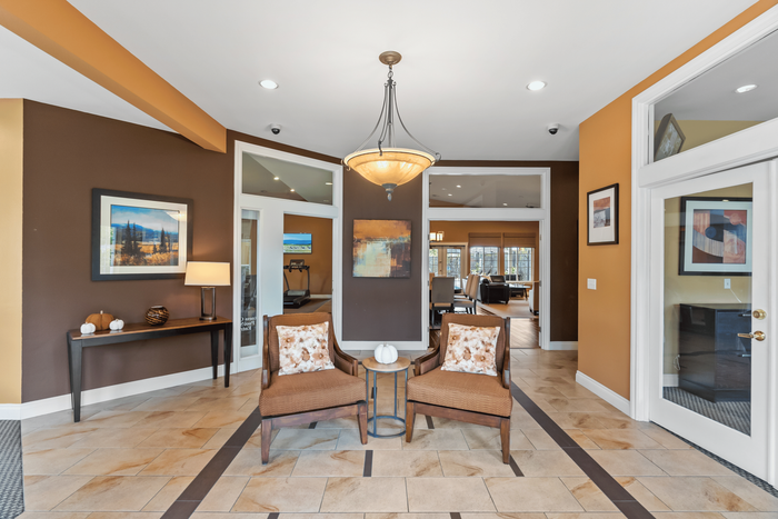 Elegant apartment lobby with warm earth tones, stylish seating, and artistic decor, creating a welcoming atmosphere.