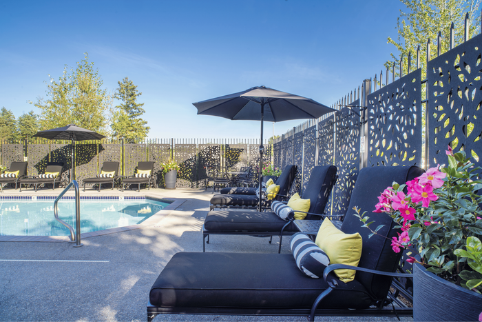 Inviting poolside retreat with elegant lounge chairs, umbrellas, and vibrant flowers creating a serene atmosphere.