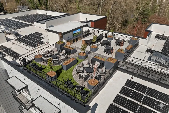 Luxurious rooftop oasis featuring elegant seating areas, lush greenery, and a modern outdoor bar with panoramic views.