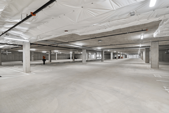 Expansive underground parking garage with ample lighting and organized spaces, offering secure and convenient parking options.