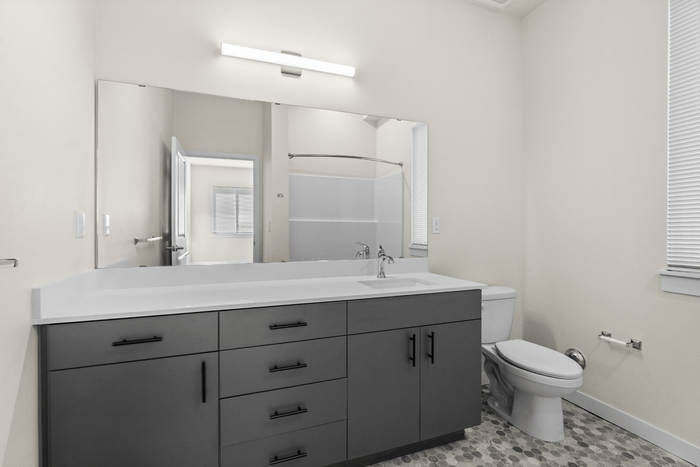 Sleek modern bathroom with spacious vanity, elegant lighting, and neutral tones for a calming atmosphere.