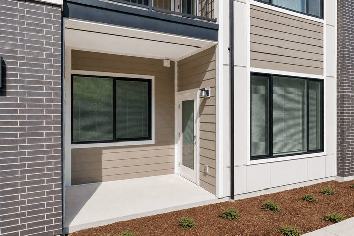 Modern apartment exterior with clean lines, featuring large windows and a stylish entry door, perfect for enjoying natural light.
