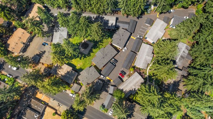 Aerial view showcasing a serene residential neighborhood surrounded by lush green trees and well-maintained roads, offering a peaceful living environment.