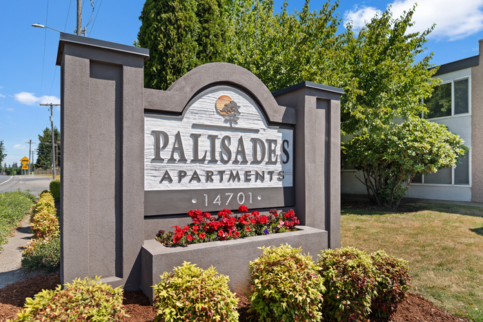 Welcoming entrance of Palisades Apartments with vibrant landscaping and modern design.