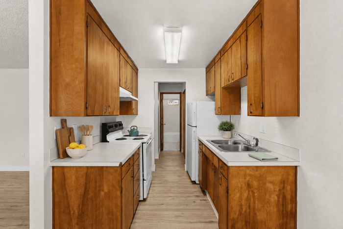 Charming galley kitchen with warm wood cabinetry, sleek countertops, and bright natural lighting.