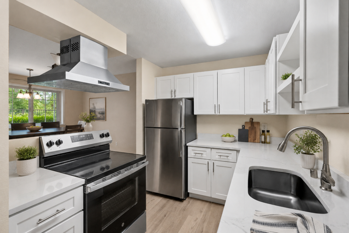 Modern kitchen with sleek stainless steel appliances, white cabinets, and elegant countertops providing a bright and inviting atmosphere.