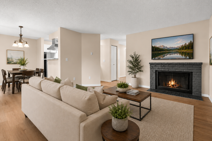 Inviting living room with cozy fireplace, elegant beige sofa, and modern dining area, perfect for entertaining.