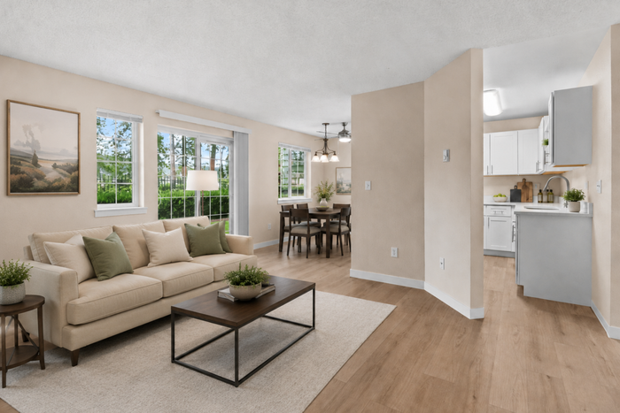 Inviting open-concept living and dining area with elegant decor, abundant natural light, and a modern kitchen.