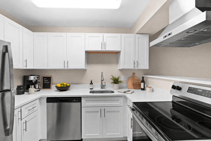 Modern kitchen with sleek white cabinets, stainless steel appliances, and elegant countertop decor.