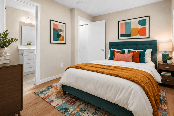 Inviting bedroom with a stylish teal headboard, vibrant abstract art, and a cozy atmosphere perfect for relaxation.