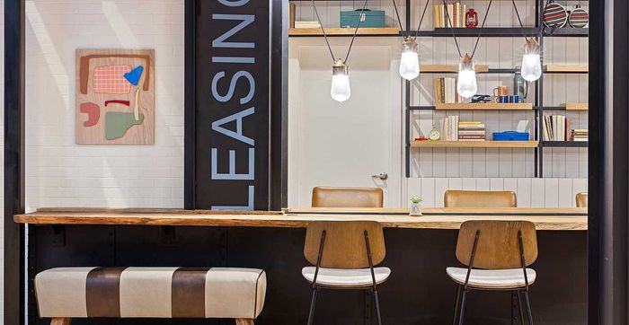 Chic leasing office with modern decor, featuring stylish pendant lighting and elegant wooden furnishings.