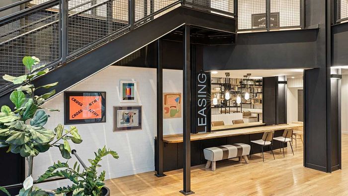 Modern leasing office with sleek black metal accents, stylish art decor, and inviting seating area.