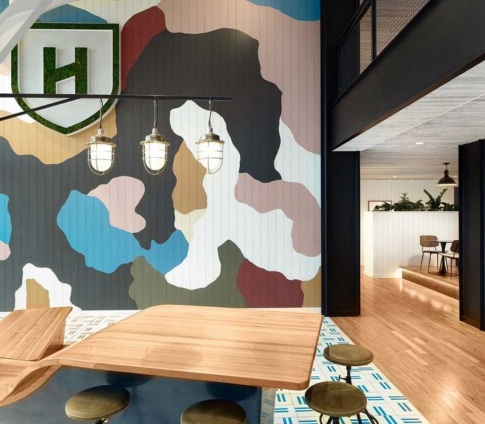 Vibrant interior showcasing a bold abstract wall mural, stylish wooden furniture, and chic pendant lighting in a modern apartment setting.