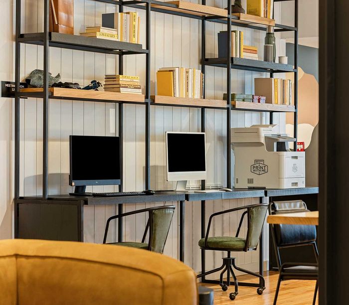 Modern home office setup with stylish shelving, two computer stations, and a high-quality printer, perfect for productivity and creativity.