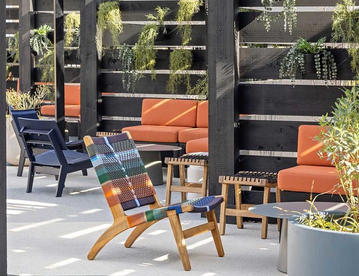 Chic outdoor patio with colorful seating and lush greenery, perfect for relaxation and social gatherings.