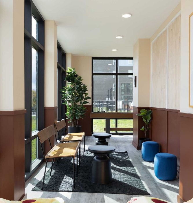 Bright and inviting seating area with modern decor, natural light, and lush greenery, perfect for relaxation.