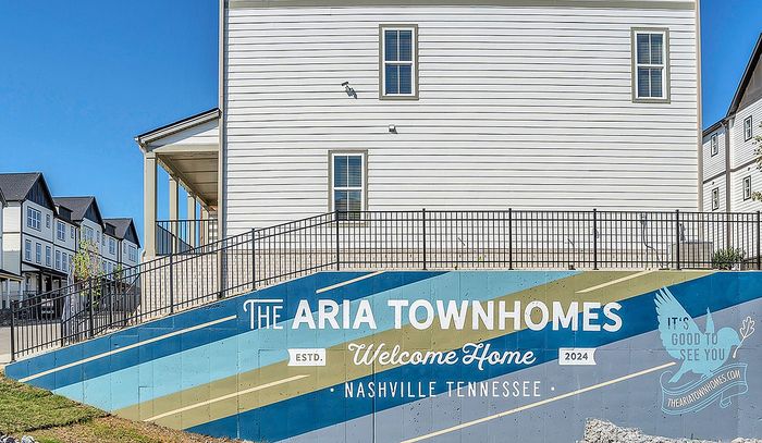 Exterior view of The Aria Townhomes in Nashville, showcasing a welcoming mural.