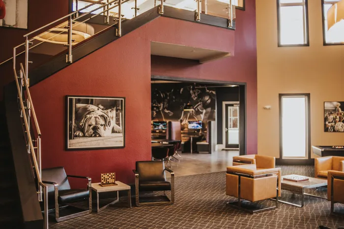 Spacious and modern apartment lobby featuring stylish leather seating, artful decor, and an inviting open layout.