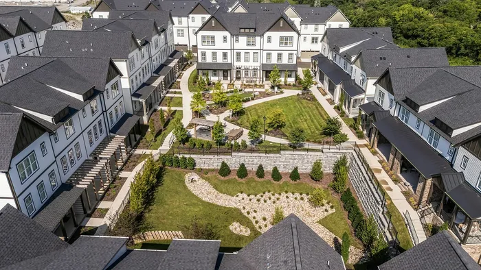 Charming apartment complex featuring modern townhouses, lush landscaped gardens, and inviting outdoor spaces, perfect for vibrant community living.
