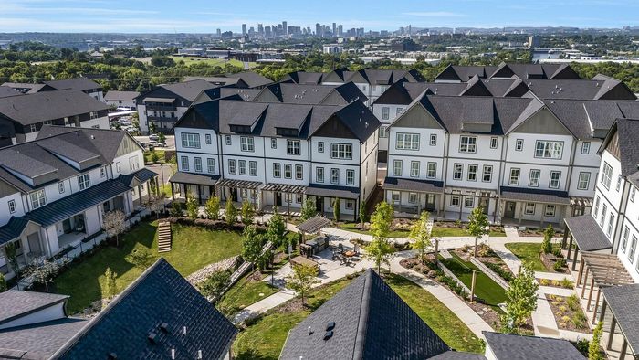 Charming townhouse community with modern architecture and lush green spaces, offering stunning city skyline views.