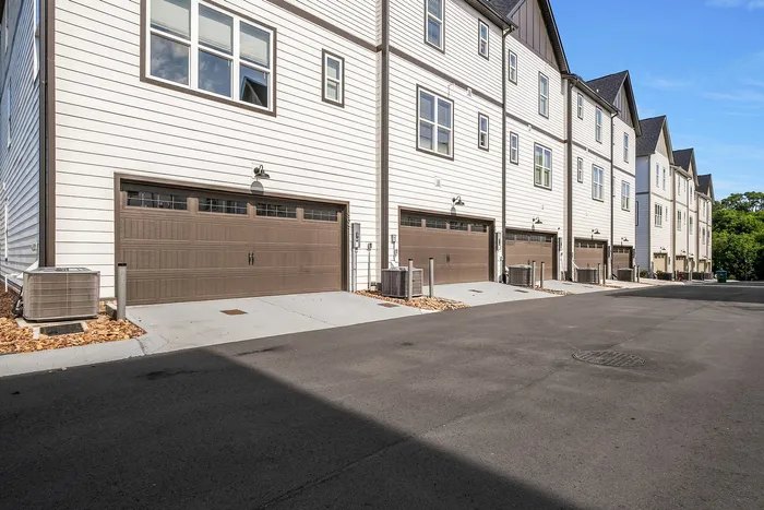 Modern row of stylish townhouses with spacious garages and contemporary architecture in a serene neighborhood.