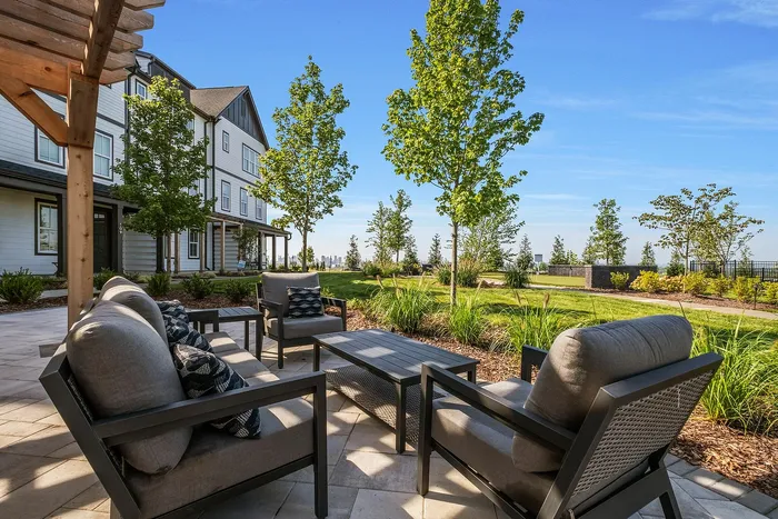 Charming outdoor seating area with modern chairs overlooking a lush garden and stunning views, perfect for relaxation.