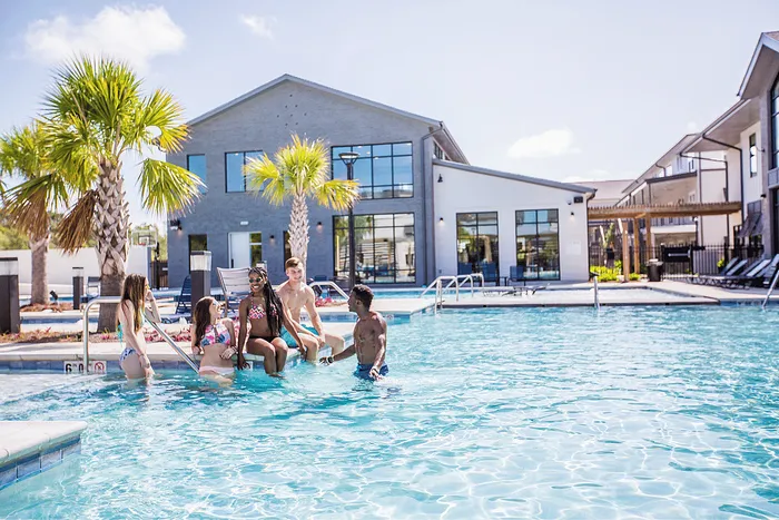 Students relaxing in resort-style pool at Wildwood Baton Rouge student apartments near LSU