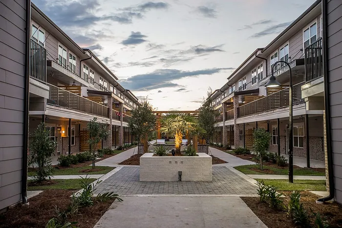 Landscaped courtyard walkway between buildings at Wildwood Baton Rouge student apartments near LSU
