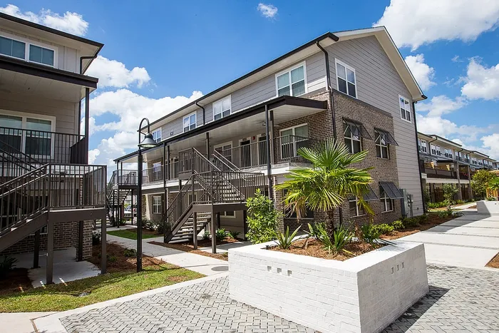 Exterior view of student apartment buildings and landscaped courtyard at Wildwood Baton Rouge apartments near LSU