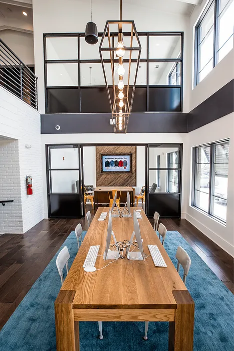 Modern study lounge with computers and large communal worktable at Wildwood Baton Rouge student apartments near LSU